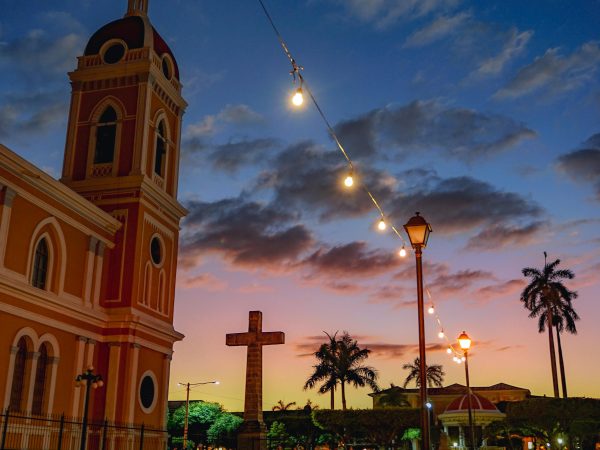Stunning view of Granada Cathedral at dusk with vibrant sunset sky and city lights.